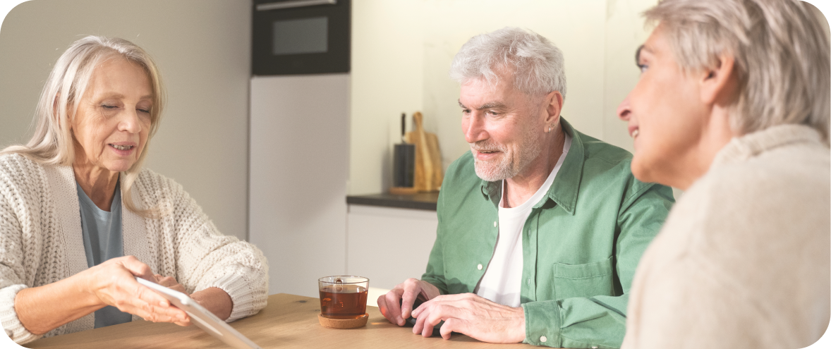 A photo of a family sitting around a table and discussing end of life planning.