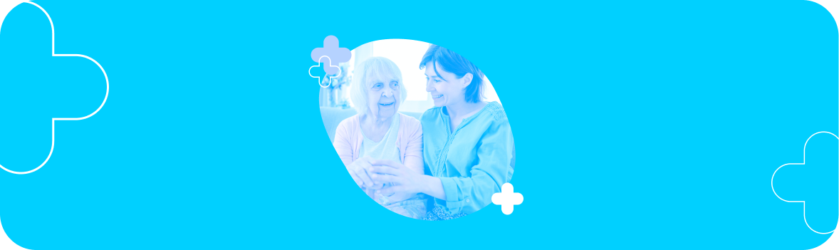 A photo of an older woman and younger woman sitting together and smiling.