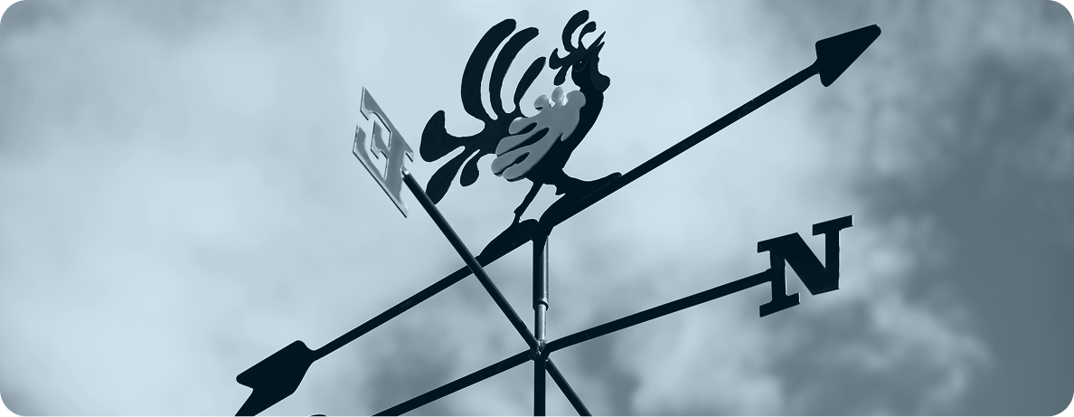 A black and white photo of a weathervane. 