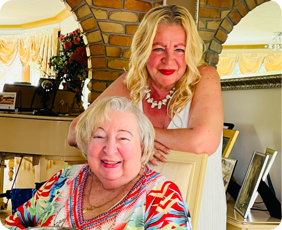 Lynn and her Mum, Clare, pose for a photo and smile. Clare receives 24-hour home care from The CareSide, among other services.