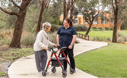 A Home Care Package recipient enjoys a walk outside with her caregiver.