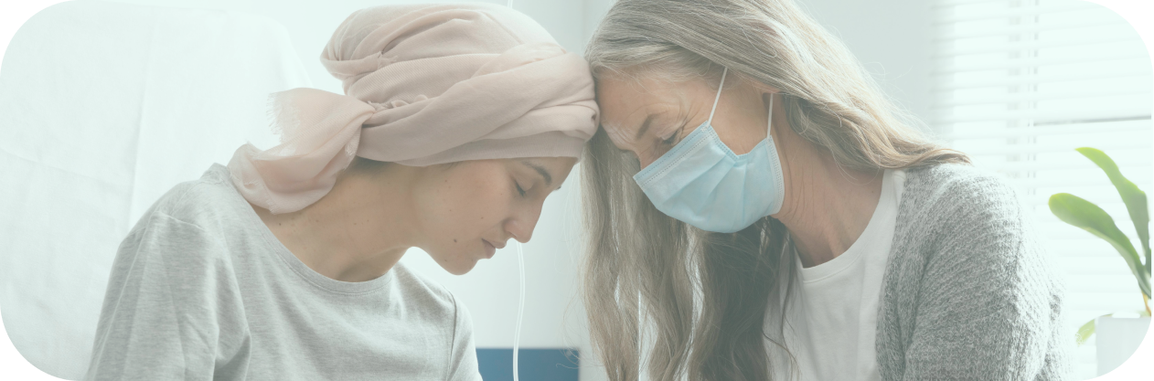 A photo of two people affectionately touching their heads together as they discuss cancer home care.