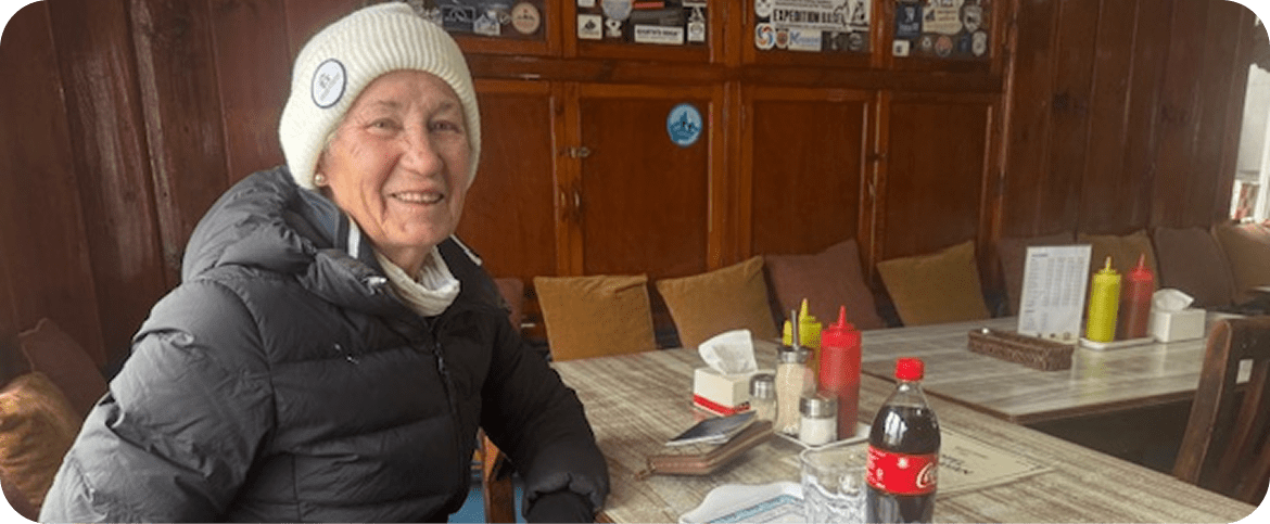 Australian trekker Carolyn Robinson smiles for a photo while sitting at a restaurant.