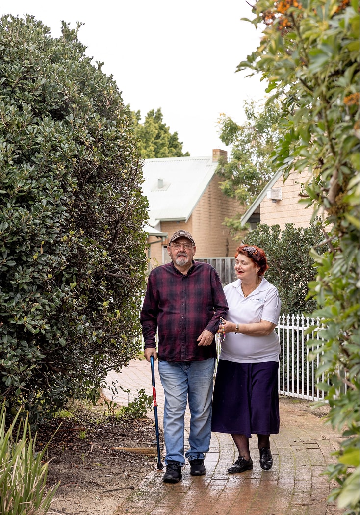 A support worker delivers care services in Canberra while helping a home care recipient enjoy a walk outside.