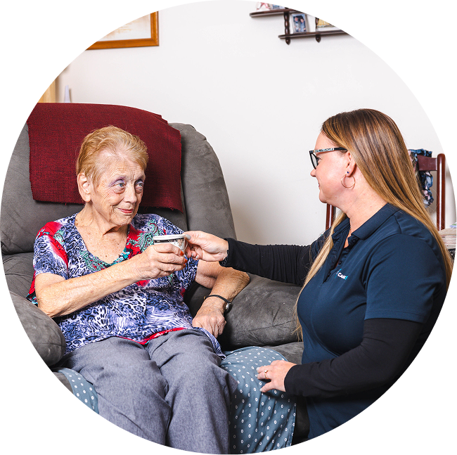 A photo of a home care in Alice Springs as a support worker from The CareSide hands a cup of tea to a happy home care recipient.