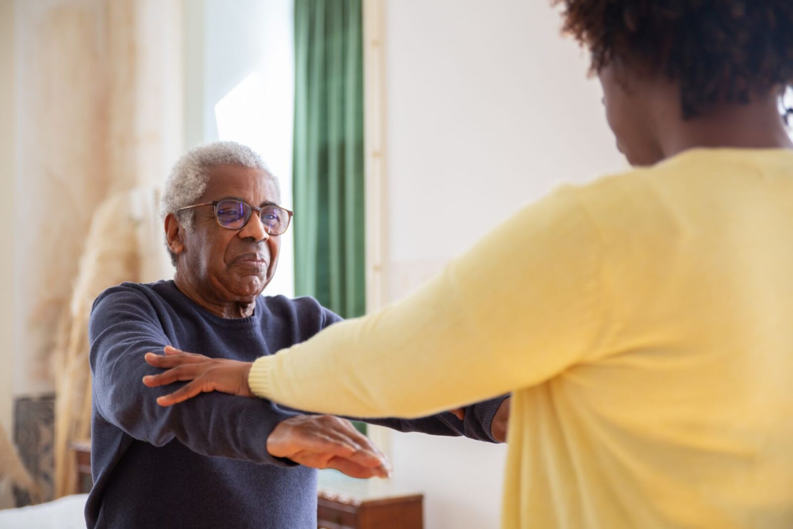 A Support at Home caregiver helps a home care recipient with exercises.